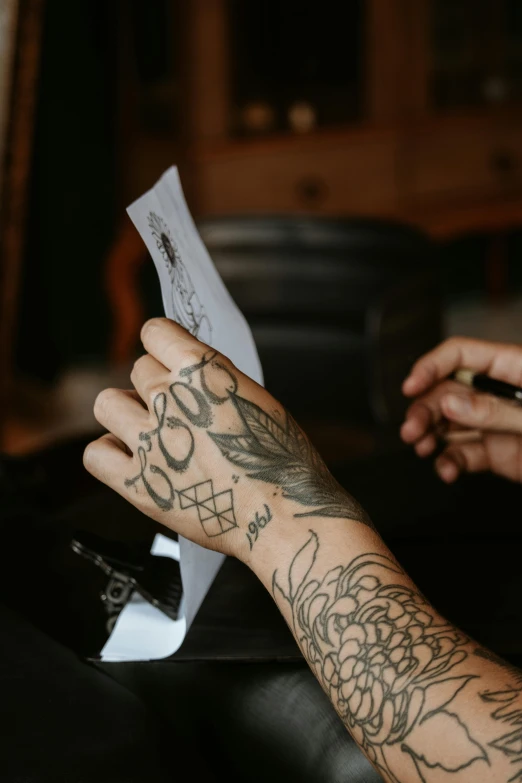 an arm and a hand holding a piece of paper with words and symbols