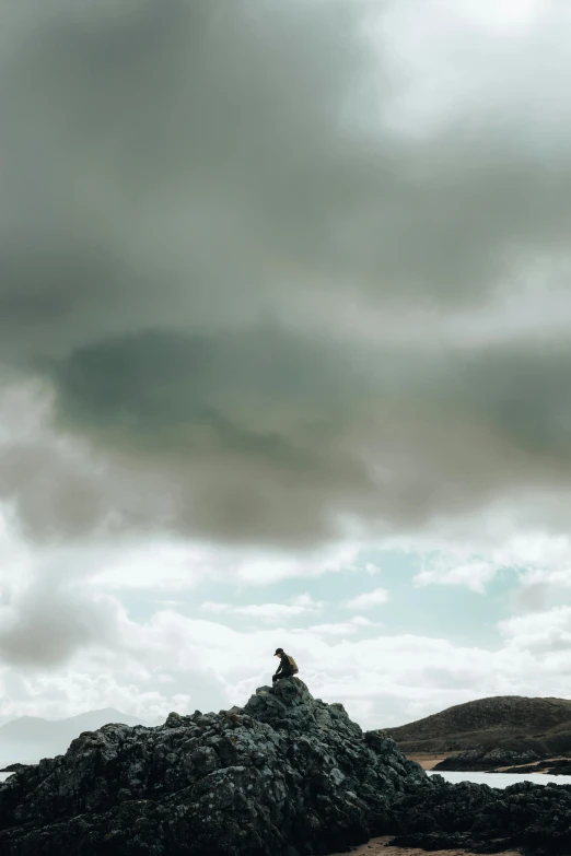 a person on top of rocks looking off into the distance