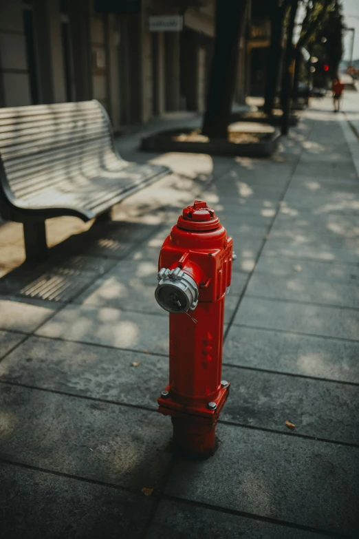 an ornate fire hydrant with a wooden bench nearby