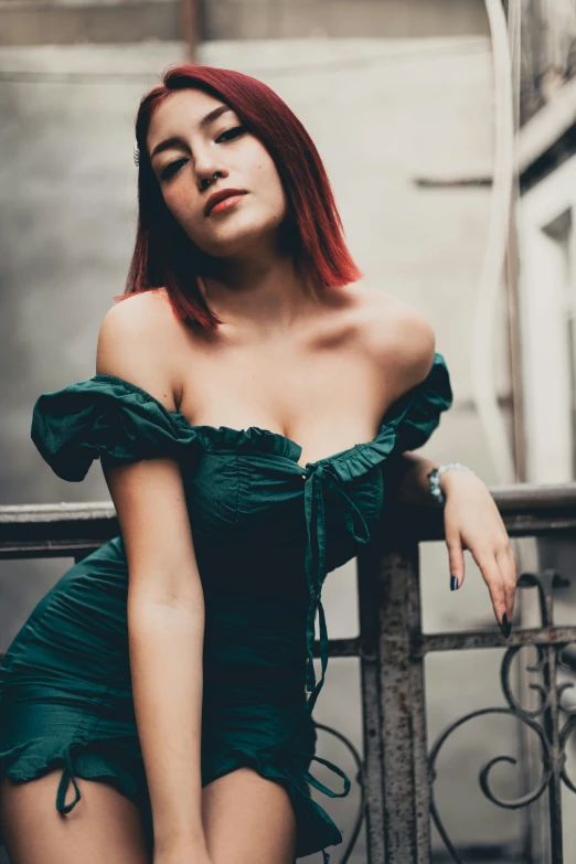 a woman with red hair poses on a balcony