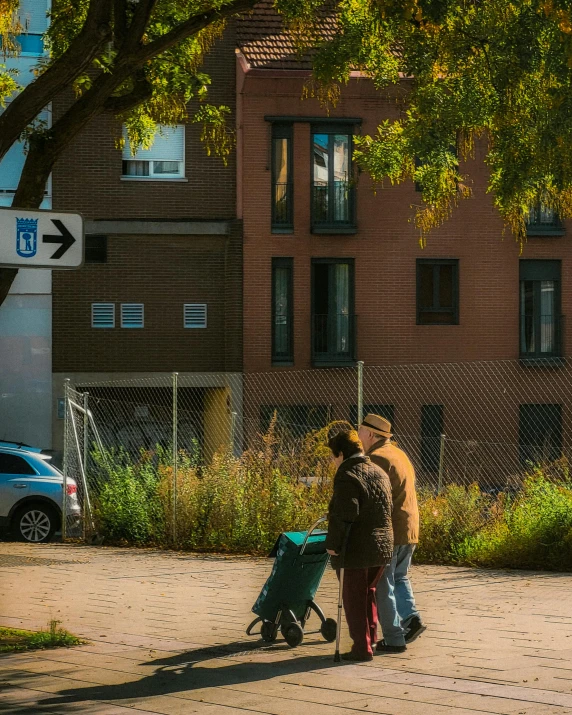 two people with a suitcase on a sidewalk