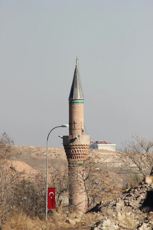 a tall brick tower on the side of a hill