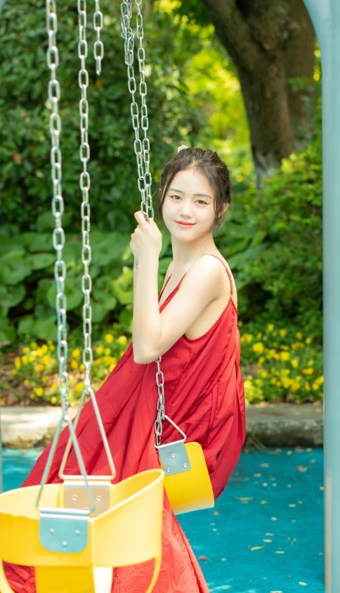 a young woman holding onto a yellow and blue swing