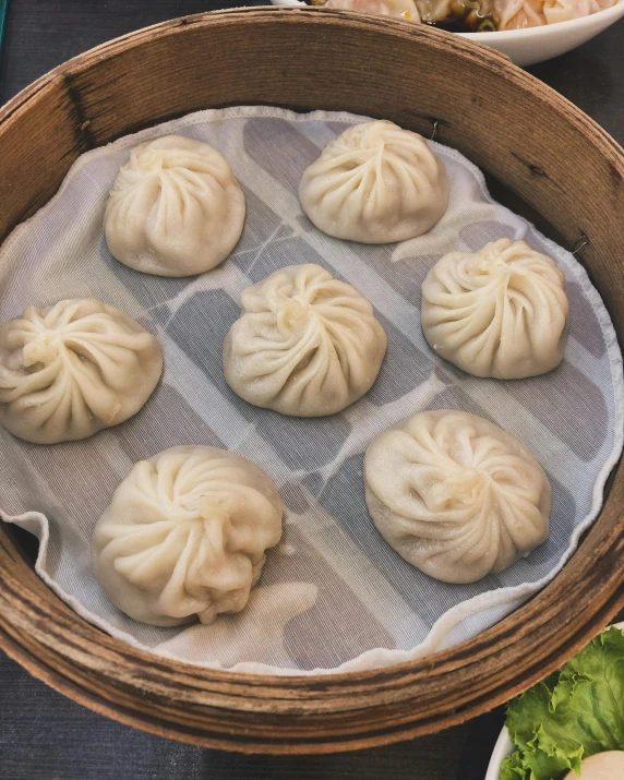 an asian dish consisting of steamed dumplings in bamboo steamer bowl