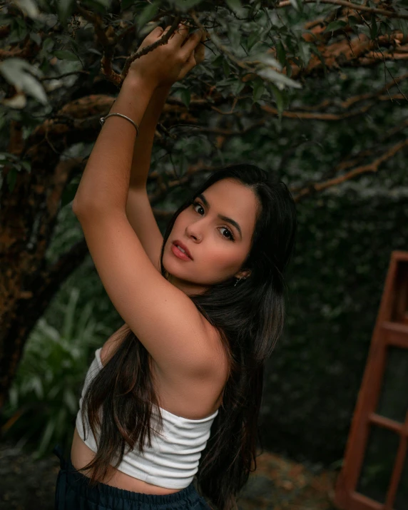 a pretty young woman holding a green leaf