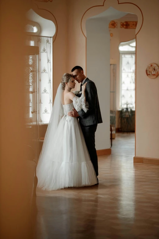 a bride and groom hugging in the hallway