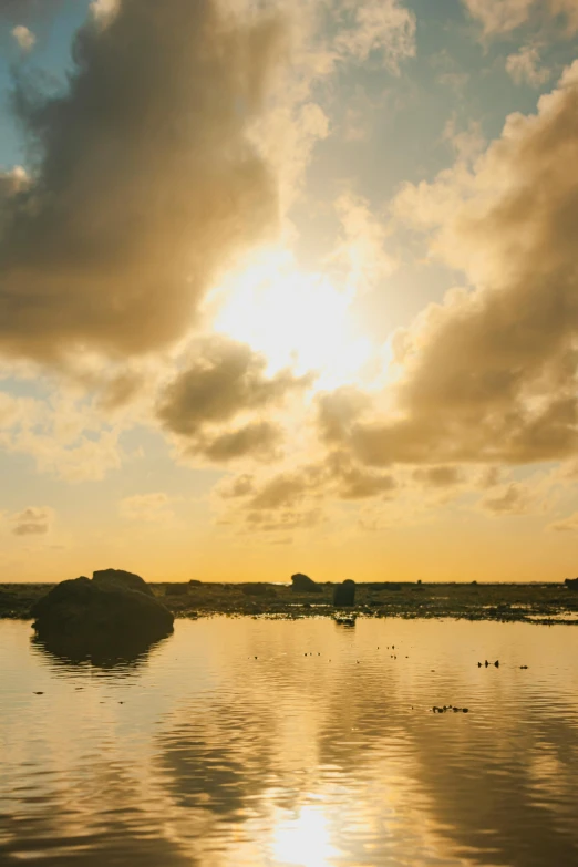 the sun is reflected in the water on a beach