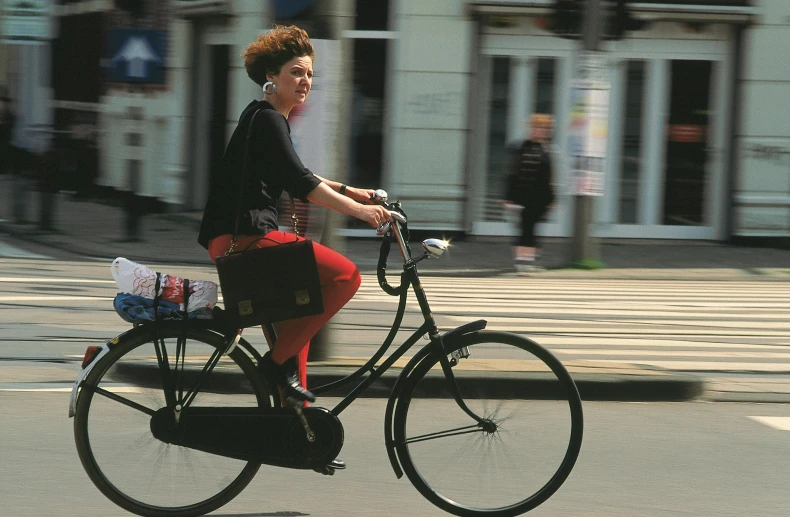 a lady riding a bike down the street