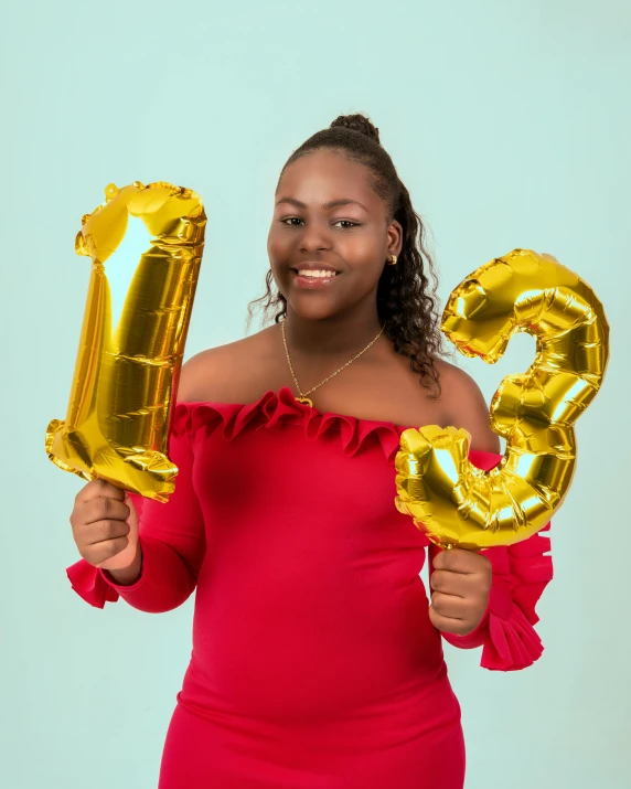 a woman in a red dress holding a pair of balloons with the letter g on it