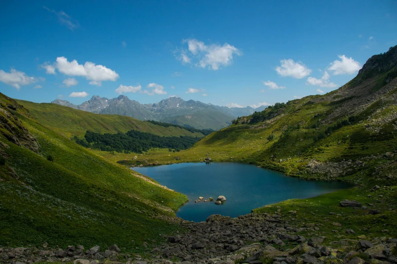 a mountain landscape with a blue lake surrounded by mountains