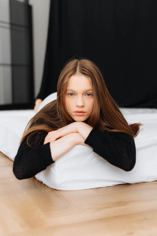 there is a girl with long hair sitting on the bed