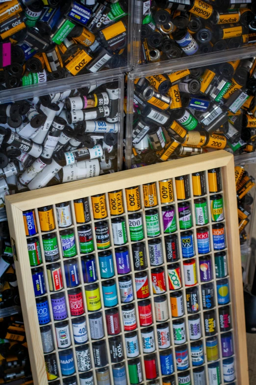 many different assorted cans of paint next to a framed artwork