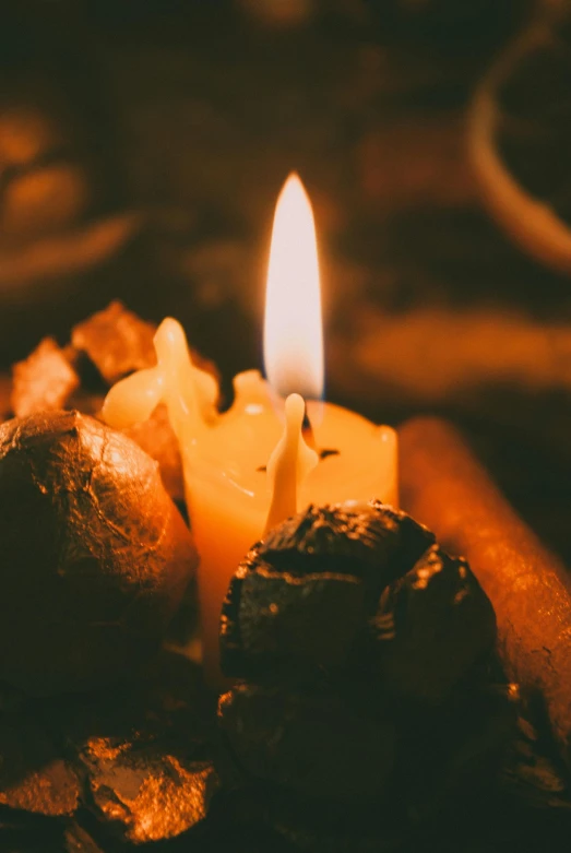 a candle in a dark room on a wooden table