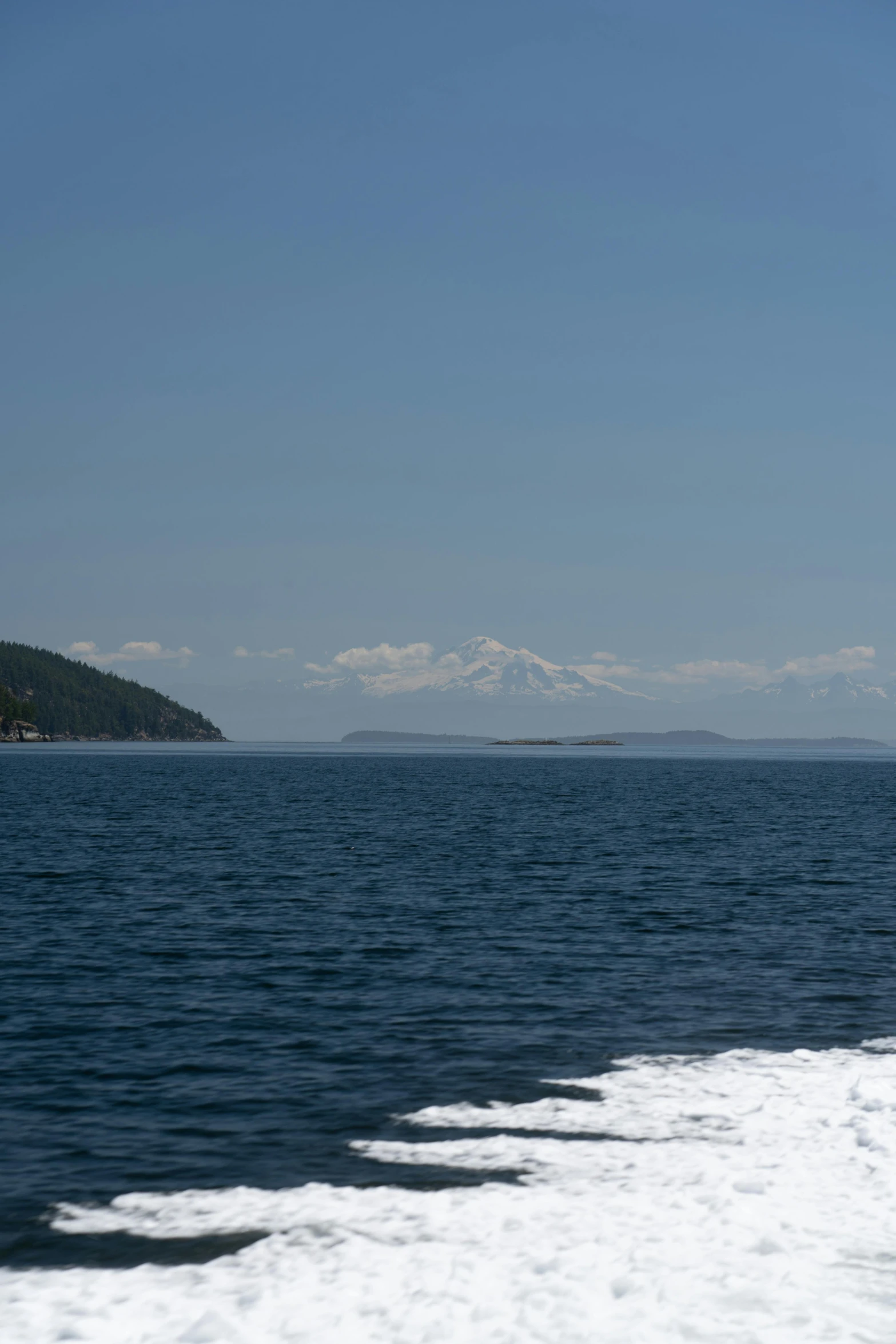 an ocean and distant islands sit at the end of a large body of water