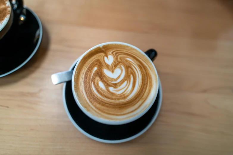 a cup of cappuccino with some heart shapes in it