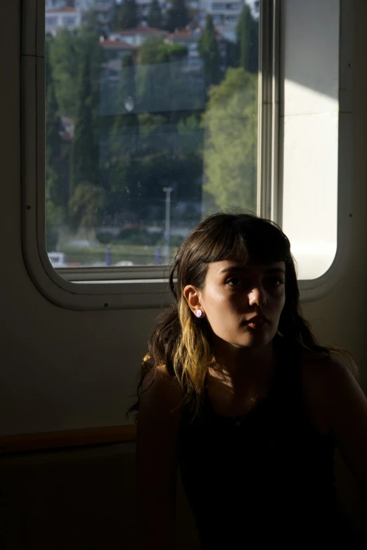 a young woman sitting on top of a boat next to a window