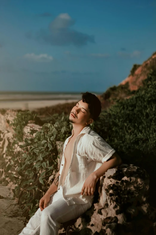 a man is sitting on top of some rocks