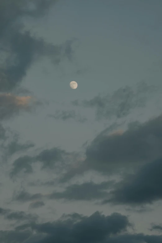 the moon is shining on some cloudy skies