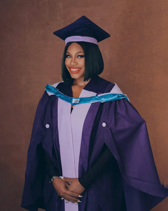 a smiling woman in a graduation gown and bonnet