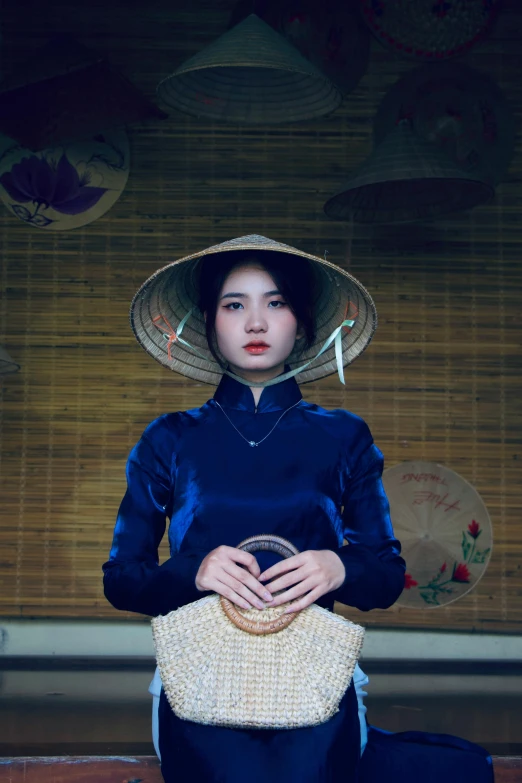 the woman is posing with a straw hat