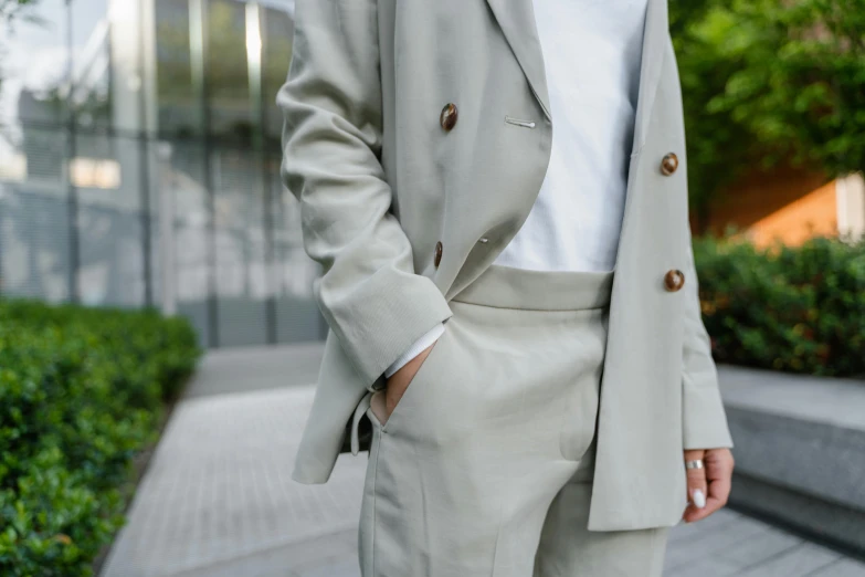 a woman wearing a white shirt and slacks outside