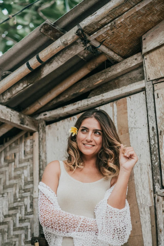 a woman posing by an old wood building