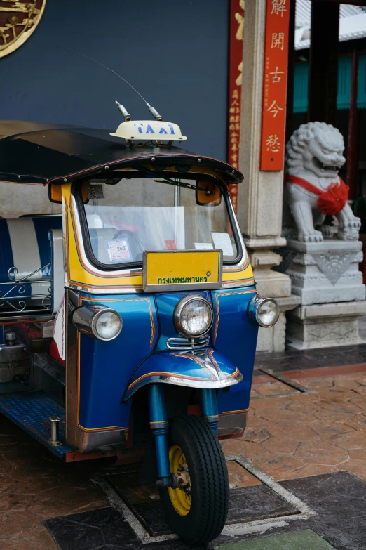 a small blue van is on display next to an entrance