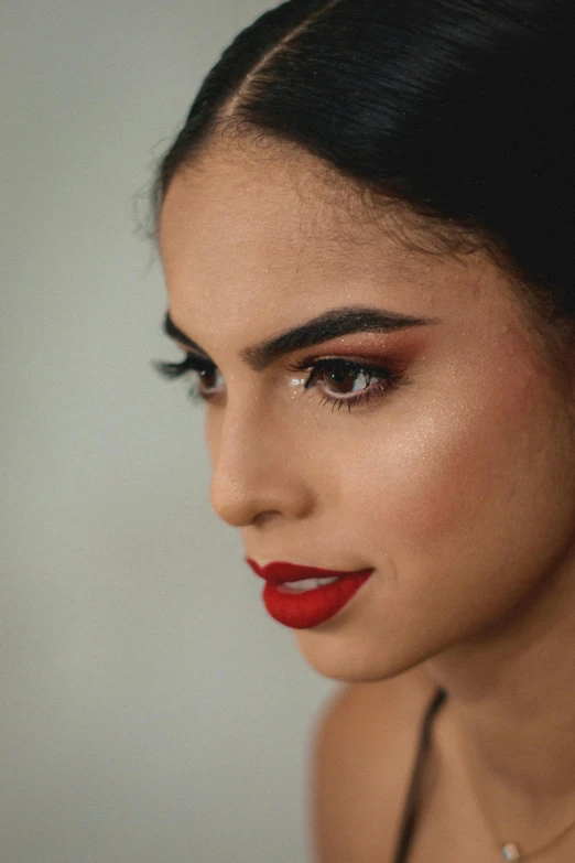 a close - up of a woman with red lips wearing an evening makeup