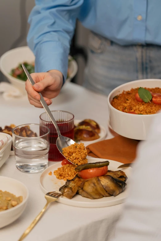 someone is holding a spoon to some food on a plate