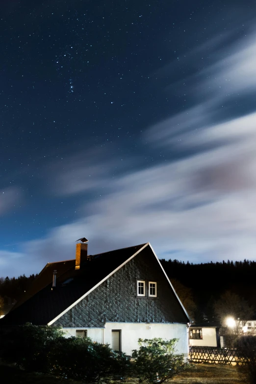 the night sky with stars above a home