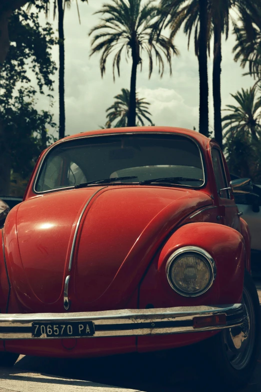 an old red car parked in the street