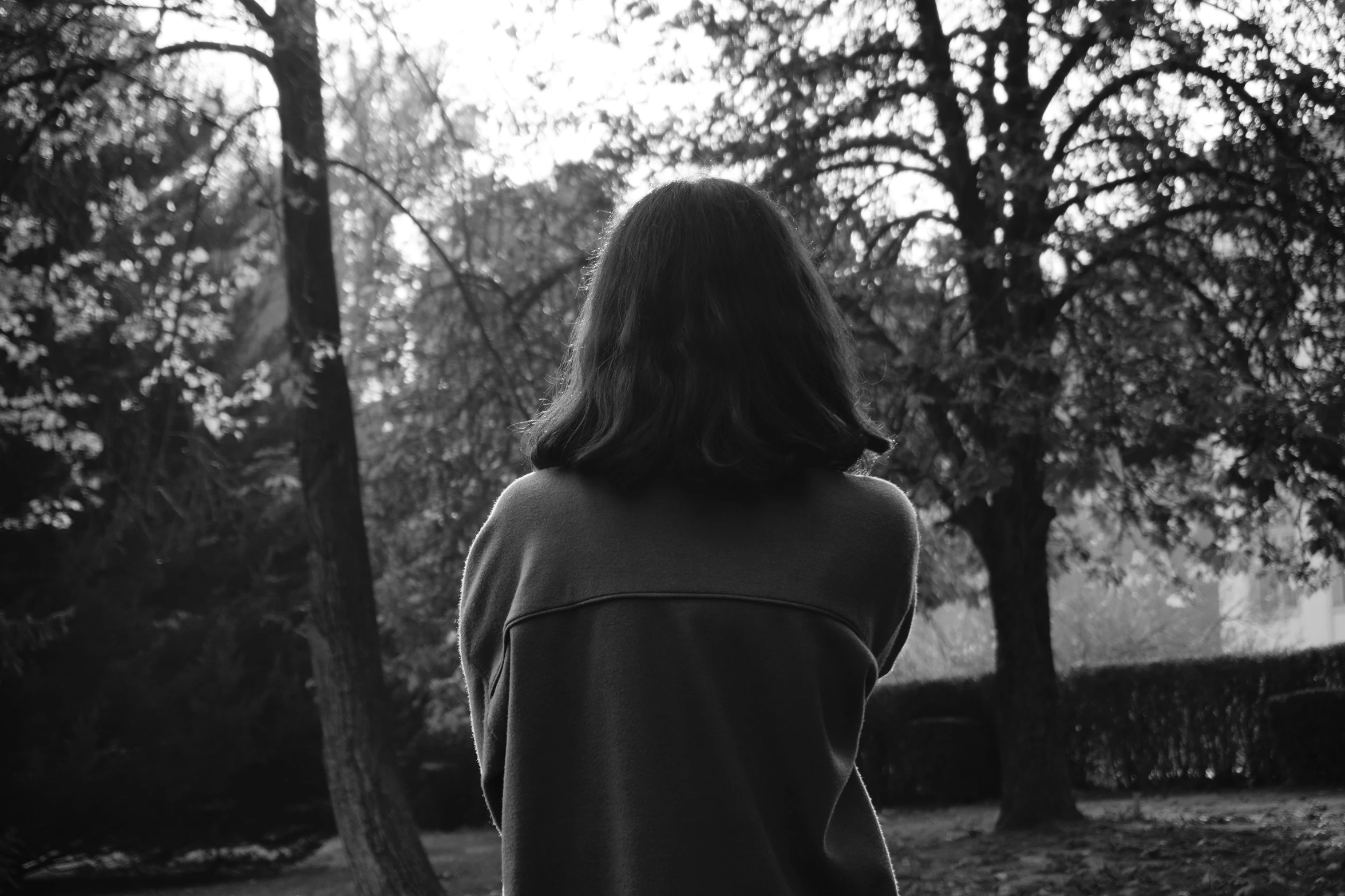 a woman standing in the middle of an area next to a tree