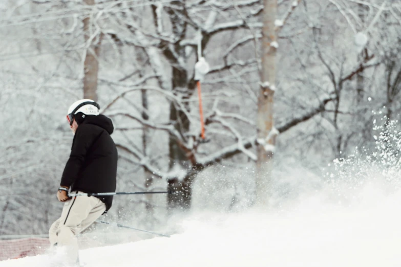 a person wearing snow skis with trees in the background