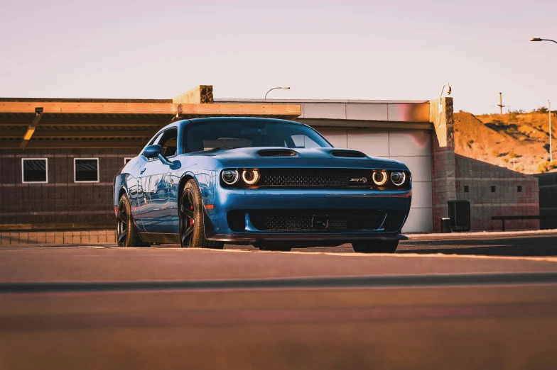 a blue sports car sitting in the middle of a street