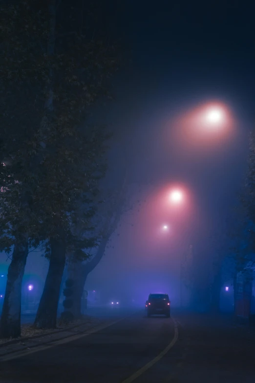 the road at night has three street lights above it