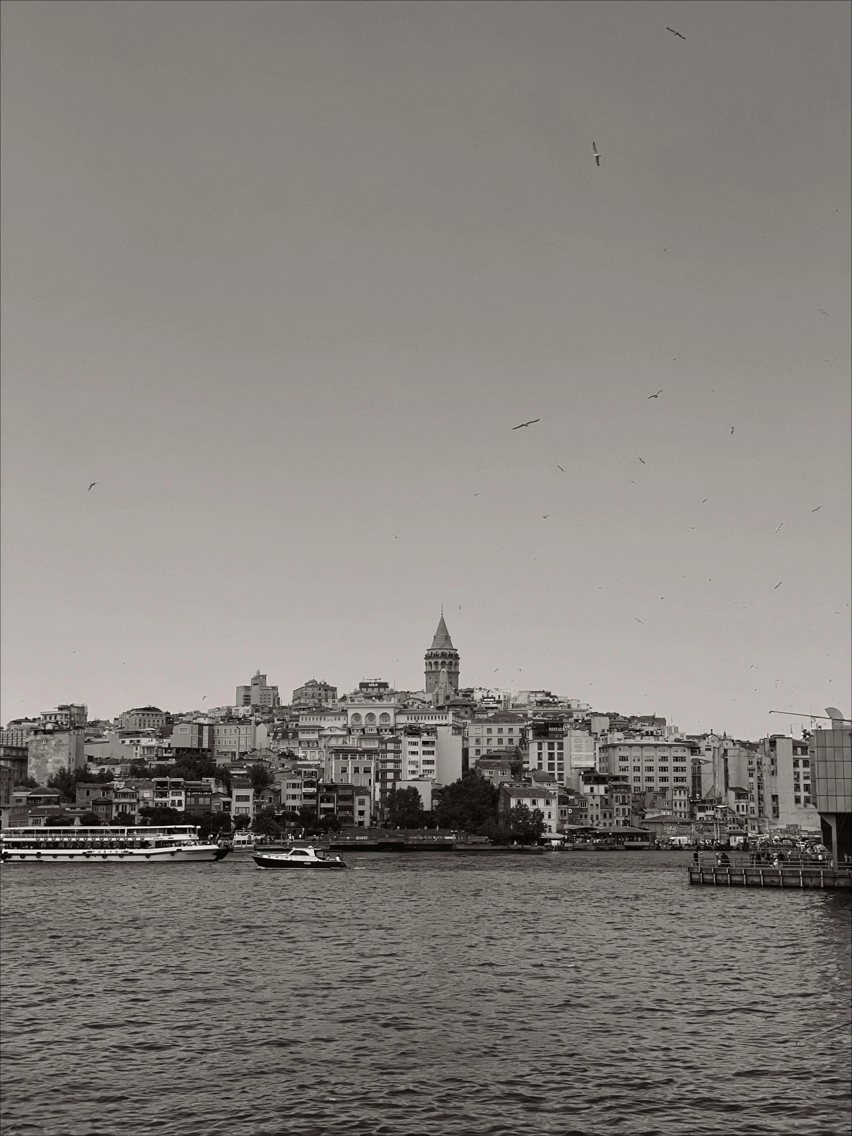 many boats sailing in the water in front of some buildings