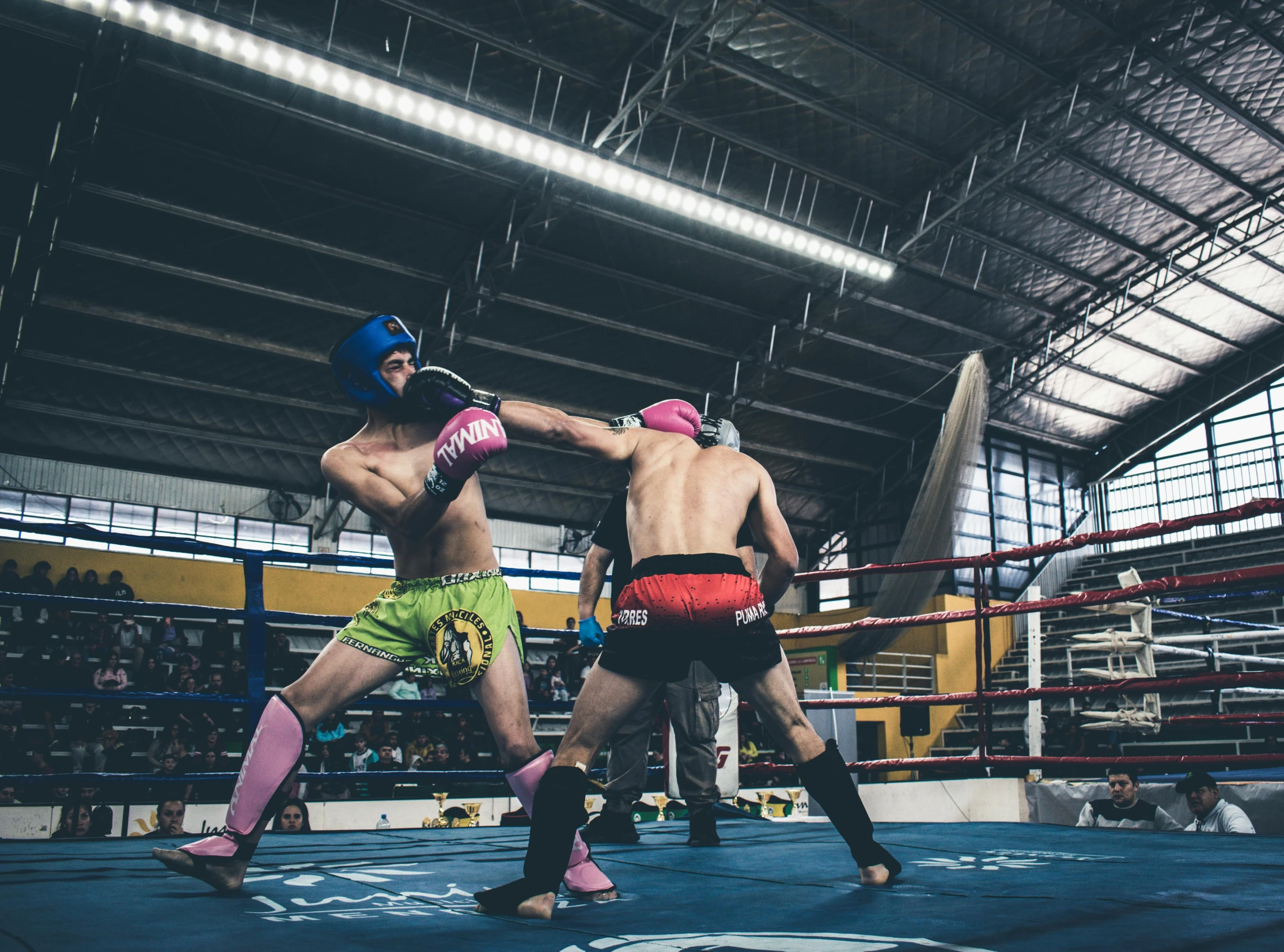 two boxers standing next to each other in a boxing ring