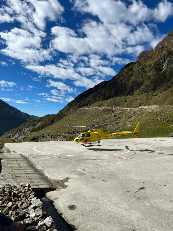 a helicopter that is on the ground next to mountains