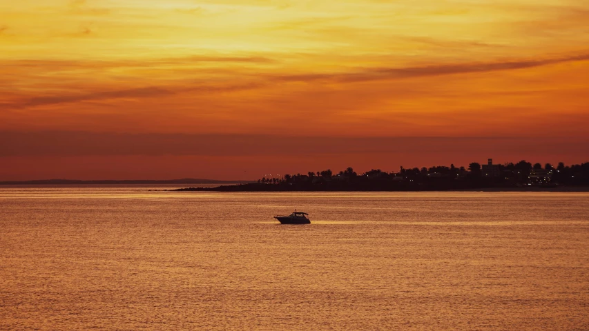 a boat with two people on it moving across the water