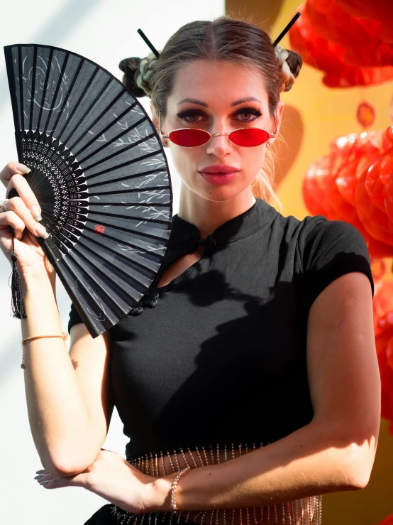 woman holding up a decorative folding paper fan