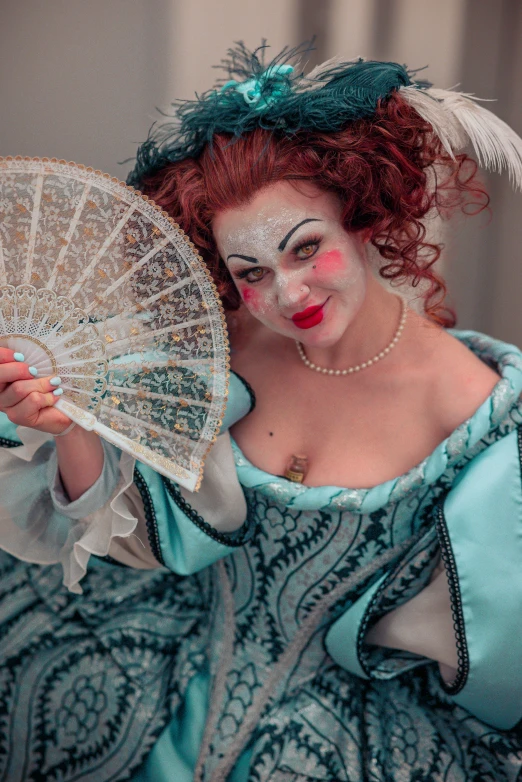 a woman with face painted as a peacock holding a fan