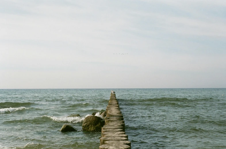 a pier stretching out into the ocean with water rolling over it