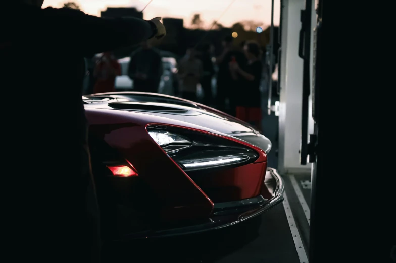 a car is parked on the road next to a bunch of people