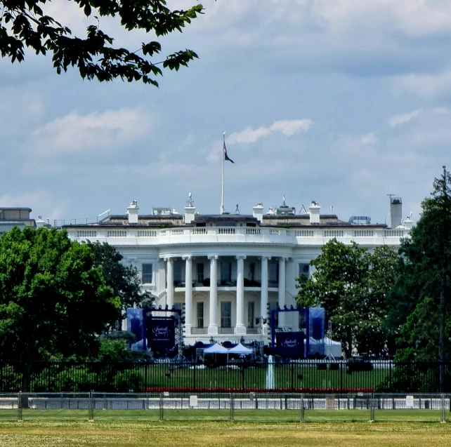 an exterior view of the white house with trees in front