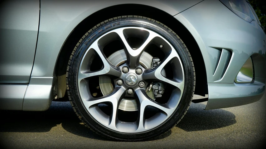 the wheels on a silver car are shown with black rims