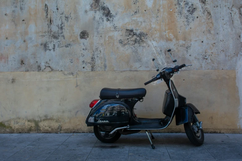 a small scooter parked by a wall