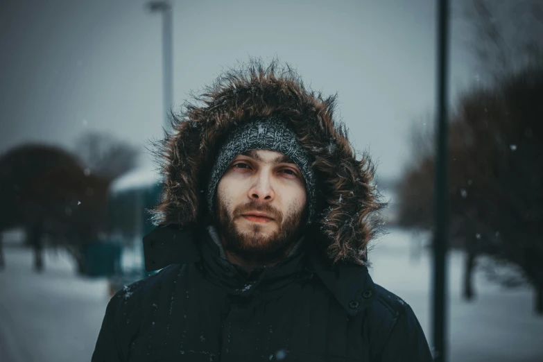 a man in a black jacket is standing outside