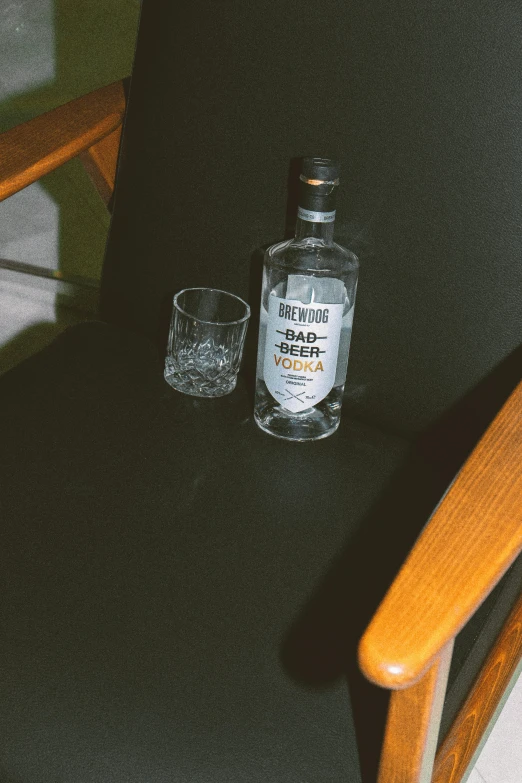 an empty bottle of whisky sitting next to two glasses