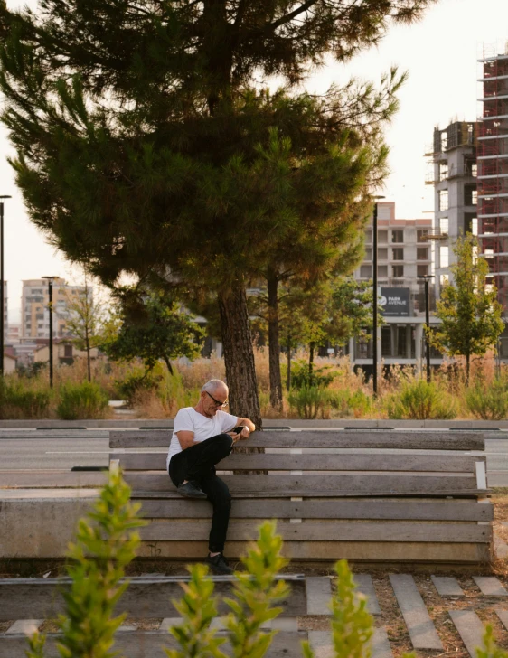 a man that is sitting on top of a bench