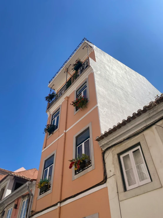 an orange and beige building has white windows